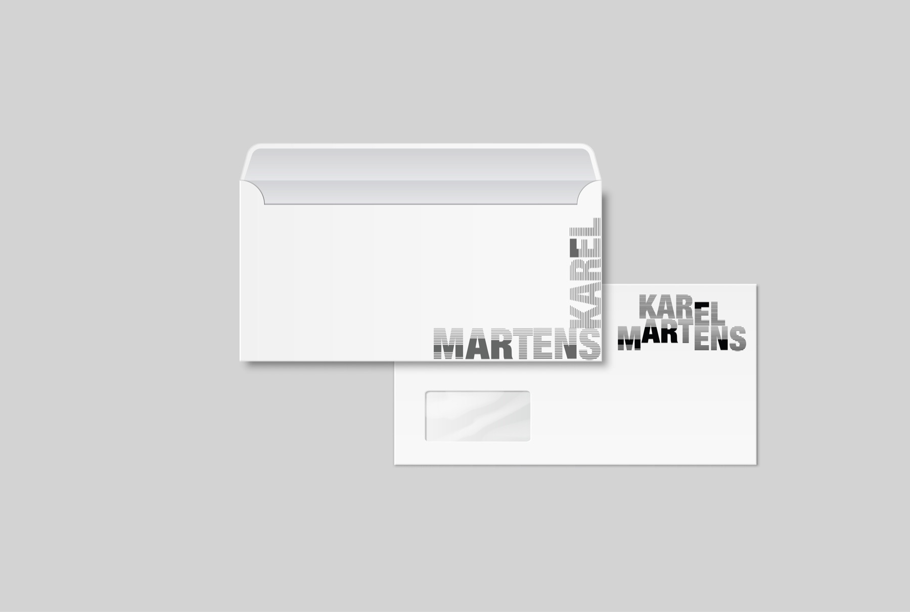 Close view of the windowed envelope with the business card resting on it, the striped MARTENS and KAREL wordmarks running off both edges.